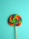 Rainbow swirl lollipop on pastel blue background Royalty Free Stock Photo