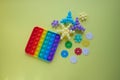 A rainbow toy and puzzles lie on a yellow background. Blue and Orange Funny Interactive Anti-Stress Silicone Toys. Pop