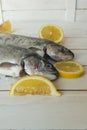 Rainbow trout over sea salt with pieces of lemon over Mediterranean wooden background
