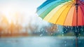 Rainbow umbrella protecting from falling rain, creating a vibrant scene with glistening water and a warm, sunny glow Royalty Free Stock Photo