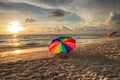 Rainbow umbrella on White sand at Delnor Wiggins State Park at sunset