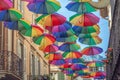 Rainbow umbrellas on blue sky background. Many colorful umbrellas, street decoration for festivals. Concept diversity Royalty Free Stock Photo