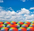 Rainbow umbrellas on cloudy sky Royalty Free Stock Photo