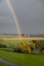 A rainbow visible very close over the green fields in southern Sweden after a summer rain Royalty Free Stock Photo