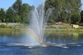 Rainbow from a water fountain in a small lake Royalty Free Stock Photo