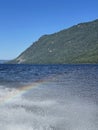 Rainbow in the water spray of Lake Teletskoye in sunny day. Altai, Russia. Royalty Free Stock Photo