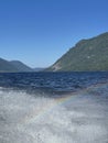 Rainbow in the water spray of Lake Teletskoye in sunny day. Altai, Russia. Royalty Free Stock Photo