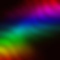 Rainbow wavy blurred gradient on black background.