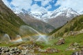 Rainbows in irrigation water spouts in Summer Alps mountain Royalty Free Stock Photo