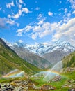 Rainbows in irrigation water spouts in Summer Alps mountain Royalty Free Stock Photo