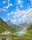 Rainbows in irrigation water spouts in Summer Alps mountain Royalty Free Stock Photo