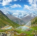 Rainbows in irrigation water spouts in Summer Alps mountain Royalty Free Stock Photo