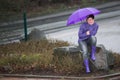 Raincoat dressed woman waiting in the rain Royalty Free Stock Photo