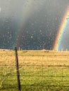 Raindrop glass with two rainbows in a field