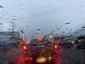 Raindrop on window glass with blurred of car on the road when traffic jam in the rainy season. Royalty Free Stock Photo