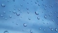 Blue glass with raindrops background texture horizontal top view isolated, rain on the window backdrop, abstract light bokeh.