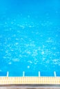 Raindrops in the blue swimming pool, gently ripple surface of water, blurred terrace foreground. Exterior tropical pool. Selective Royalty Free Stock Photo