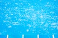 Raindrops in the blue swimming pool, gently ripple surface of water, blurred terrace foreground. Exterior tropical pool. Selective Royalty Free Stock Photo