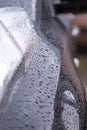 Raindrops on the car. Car element with raindrops close-up. Doors and door handle of a black car in raindrops. Big raindrops on the Royalty Free Stock Photo