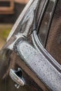 Raindrops on the car. Car element with raindrops close-up. Doors and door handle and glass of a black car in raindrops. Big Royalty Free Stock Photo