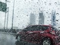 Raindrops on car glass at city in rainy day Royalty Free Stock Photo