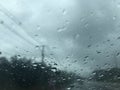 Raindrops on the car`s windscreen and blurred countryside road view Royalty Free Stock Photo