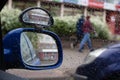 Raindrops on car side view mirror and window closeup. Bad weather driving Royalty Free Stock Photo