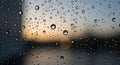 Raindrops cling to a window, creating a textured surface through which a blurred sunset is visible. Royalty Free Stock Photo