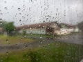 Raindrops cling to a windowpane, creating intricate patterns and distorting the muted view beyond. Royalty Free Stock Photo