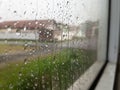 Raindrops cling to a windowpane, creating intricate patterns and distorting the muted view beyond. Royalty Free Stock Photo