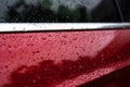 Raindrops close up on a red car body macro photo Royalty Free Stock Photo