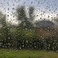 Raindrops cover a glass surface, creating a textured pattern with water droplets. The Royalty Free Stock Photo
