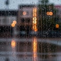 Raindrops create patterns on a window, blurring the view of city lights in the Royalty Free Stock Photo