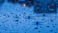 Raindrops creating ripples on a dark blue wet surface with bokeh lights Royalty Free Stock Photo