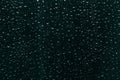 Raindrops on dark blue-green window glass as background Royalty Free Stock Photo