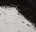 Raindrops fall on the surface of the water in the pool. Royalty Free Stock Photo