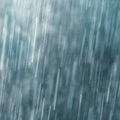 Raindrops falling against dark blue background, slow shutter speed