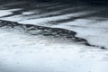 Raindrops falling into water puddle on sidewalk