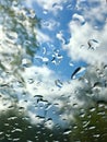 Raindrops on glass against blue sky and clouds Royalty Free Stock Photo