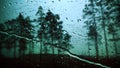 Raindrops on glass against a blue sky and woods Royalty Free Stock Photo