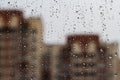 Raindrops on glass in focus on blurred building background Royalty Free Stock Photo