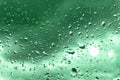 Raindrops on glass for green backdrop rainy fall autumn weather. Abstract backgrounds with rain drops on window Royalty Free Stock Photo