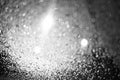 Raindrops on the glass at night. The lanterns are shining. Black and white bokeh. Car glass. Defocus. Royalty Free Stock Photo