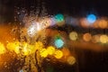Raindrops on the glass night, the light from the headlights of cars bokeh. background texture Royalty Free Stock Photo
