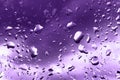 Raindrops on glass for purple backdrop rainy fall autumn weather. Abstract backgrounds with rain drops on window
