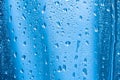 Raindrops on the glass in rainy weather.The glittering, shiny surface of water on glass.Water drops in the form of balls or