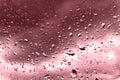 Raindrops on glass for red backdrop rainy fall autumn weather. Abstract backgrounds with rain drops on window Royalty Free Stock Photo