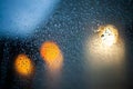 Raindrops on the glass of a window before the blurred lights - blue relaxing background