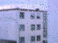 Raindrops on glass window with building view