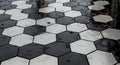 Raindrops on Hexagonal Black and White Tile Pavement Royalty Free Stock Photo